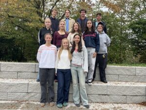 12 Schüler und Schülerinnen posieren im Atrium. Dies sind einige der Hausaufgabenbetreuer*innen des GKM im SJ 26/27