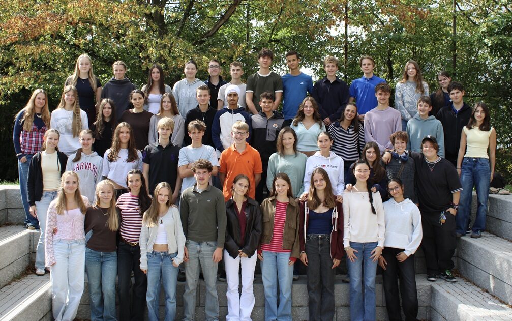 Die Zehntklässler posieren draußen für ein Gruppenbild für die Fünftklässler, deren Paten sie sind.